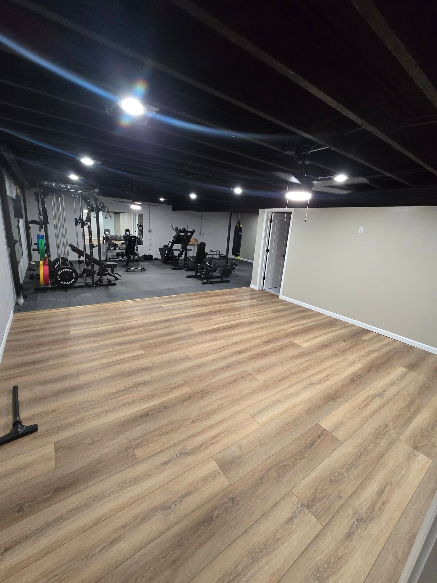 Complete basement finish at our own house — home gym, bedroom, bathroom, living room, and storage areas by B&R Construction