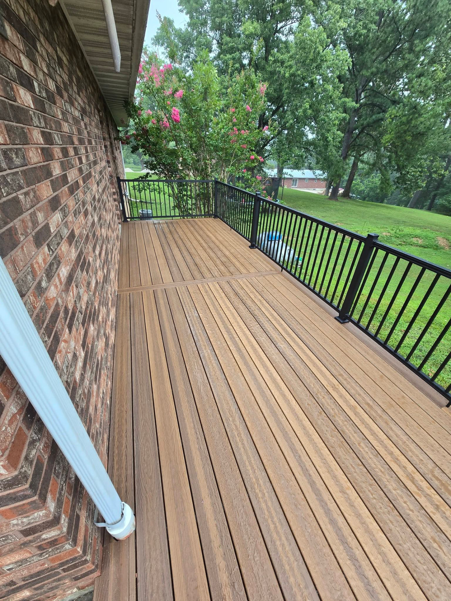 Finished composite deck with black aluminum railing by B&R Construction